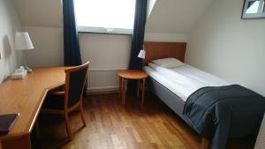 Hillerstorp哈加酒店的一间卧室配有一张床、一张桌子和一张桌子