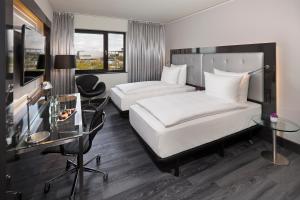 沃尔夫斯堡INNSiDE by Meliá Wolfsburg的酒店客房配有两张床和一张书桌