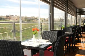 安曼Olive Hotel Amman的用餐室设有桌椅和窗户。