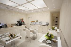 罗马三色旅馆的用餐室配有白色的桌子和白色的椅子
