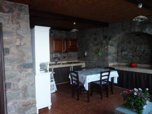 潘泰莱里亚Dammuso Kania alta的厨房配有桌子和石墙