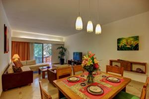普拉亚卡门玛雅海滨度假套房酒店的一间带餐桌的客厅和一间客厅。