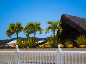纳塔尔克里斯蒂纳塔尔度假酒店的棕榈树屋前的白色围栏