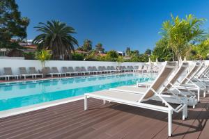 拉克鲁斯Hotel Atlantic Mirage Suites & SPA - ADULTS ONLY的游泳池旁的一排躺椅