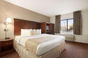 苏福尔斯苏福尔斯贝蒙特旅馆套房酒店的一间设有大床和窗户的酒店客房