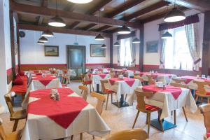 贝希特斯加登舍瓦本维特酒店的一间设有红色和白色桌椅的用餐室