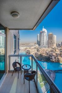 迪拜One Bedroom Apartment Dubai Fountain & Old Town View by Auberge的阳台配有桌椅,享有城市美景。