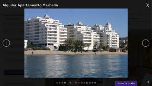 马贝拉Apartamento Marbella Playa的海滩的画面,背景是建筑