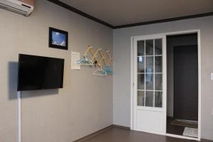 束草市Blue Door Hostel Guesthouse的客厅设有壁挂式平面电视。
