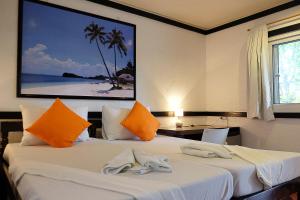 马拉帕斯加海马滩度假村的酒店客房,配有带毛巾的床