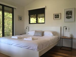 Alstonville塔拉林加景山林小屋的卧室配有一张大白色床和窗户