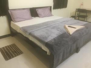 哥印拜陀ComfortWings的卧室内的一张带紫色枕头的大床