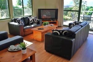 袋鼠谷SkyView Villa的客厅配有两张沙发和一台电视