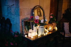 Helguera拉科蒂亚酒店的一张带鲜花、蜡烛和镜子的桌子
