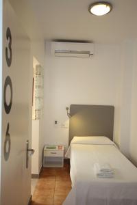 伊维萨镇伊维萨里波尔旅馆的一间卧室配有一张带白色床罩的床
