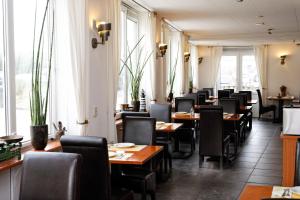 栋堡北海酒店的用餐室设有桌椅和窗户。