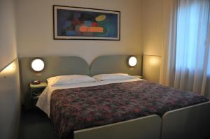 特雷维索艾克佛尔酒店的一间卧室配有一张带两个灯的大床