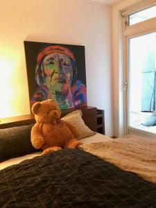 卑尔根Nice, Modern Apartment in Central Bergen的泰迪熊坐在床上,画着一幅画