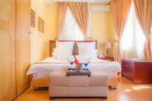阿鲁沙金冠酒店 - 阿鲁沙的酒店客房设有一张床和两个窗户。