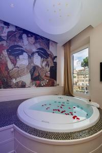 罗马托雷阿根廷和莱 - 魅力宅区酒店的浴室配有带壁画的大浴缸。