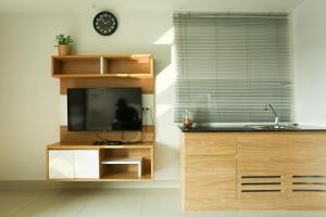 北柳JK LIVING Hotel And Service Apartment的厨房配有电视、水槽和窗户。