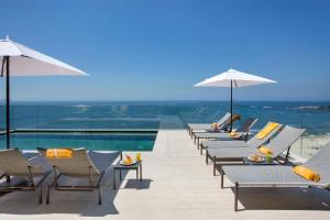 里约热内卢Windsor California Copacabana的游泳池旁的一排椅子和遮阳伞