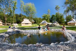 StahovicaSlovenia Eco resort的一群人坐在公园的池塘里
