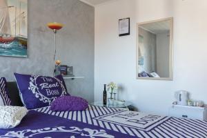 杜布罗夫尼克伊沃娜旅馆的一间卧室配有一张带紫色枕头和镜子的床
