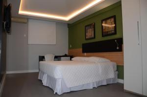 费拉迪圣安娜圣多明戈斯酒店的卧室配有白色的床和绿色的墙壁