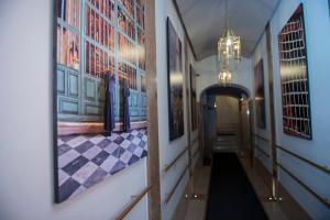 罗马托雷阿根廷和莱 - 魅力宅区酒店的墙上挂有绘画的走廊和吊灯