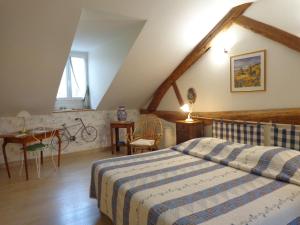 Saint-Nicolas-lès-Cîteaux西斯图尔斯住宿加早餐旅馆的卧室配有1张床、1张桌子和1把椅子