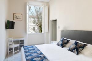 佛罗伦萨圣詹姆斯酒店的一间卧室配有一张床、一张书桌和一个窗户。