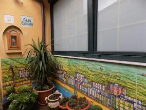 马奥莱卡萨可洛蒂德旅馆的墙上的壁画,有植物和窗户