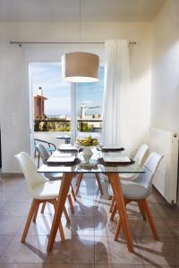 KambánionDream Villa的一间设有玻璃桌和白色椅子的用餐室