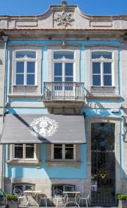 波尔图Boavista Eco-Luxury House的蓝色的建筑,配有桌子和雨伞