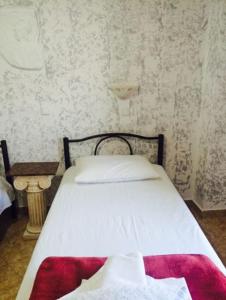 卡特瑞杜斯甜蜜之家酒店的一间卧室配有一张床铺,床上铺有红色毯子
