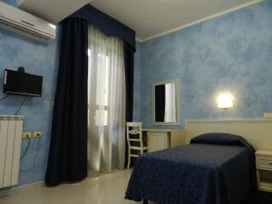 都灵灵格托空中宫殿酒店的一间拥有蓝色墙壁、一张床和镜子的卧室