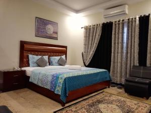 卡拉奇Seaview Lodge Guest House的一间卧室配有床、椅子和窗帘