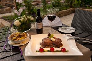 沃尔姆斯温哥特萨德维斯葡萄酒庄酒店的一张桌子,上面放着一盘食物和一杯葡萄酒