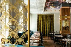 旧金山Hotel Bijou - Union Square的用餐室配有桌椅和黄色及白色的壁纸