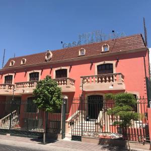 莱昂Hotel Casa Cantera的前面有黑色栅栏的粉红色建筑