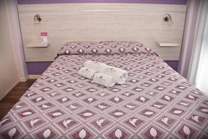 贝纳多图埃托Hotel San Marino的一张床上有两卷毛巾