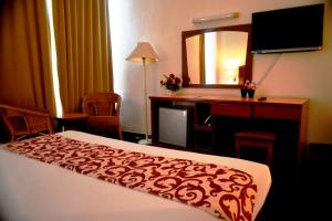 吉隆坡嘉利堡酒店的酒店客房带一张床、一张书桌和一面镜子