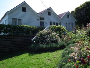 RhyllCaptain Lock's Cottage的前面有鲜花的白色房子