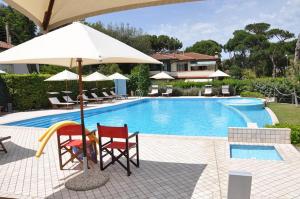蒂勒尼亚布里斯托尔酒店的一个带两把椅子和遮阳伞的游泳池
