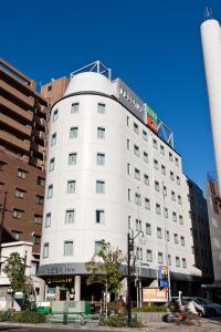 东京东京东阳町索特弗兰萨旅馆的白色的建筑,上面有标志