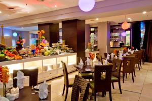 波德申Thistle Port Dickson Resort的一间带桌椅的餐厅以及一间自助餐