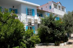 马拉松坎博斯佩拉吉娅旅馆的白色的大房子,设有蓝色的窗户和灌木丛