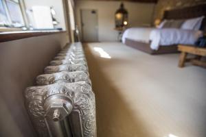 斯托昂泽沃尔德门廊之家宾馆的一间卧室,配有一张床和一个银色的行李箱