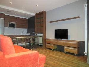奥维多克拉林公寓酒店的客厅配有橙色沙发和电视